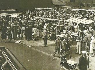 Old black and white photo of stalls and people outside Fleetwood market.