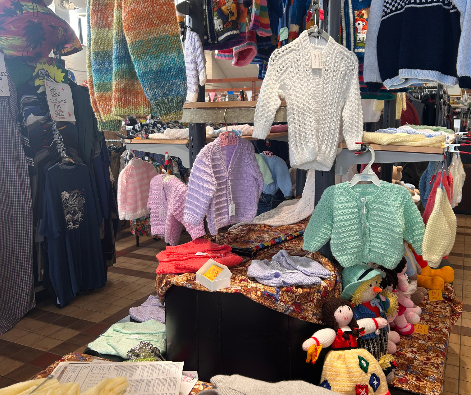 Children's hand made clothes are on a rack